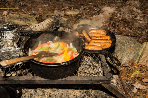 приготовление пищи на пожарной яме - fire pit fire camping campfire стоковые фото и изображения