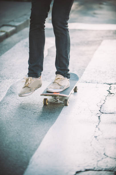 istock Skateboarder legs riding skateboard on the street 866374606