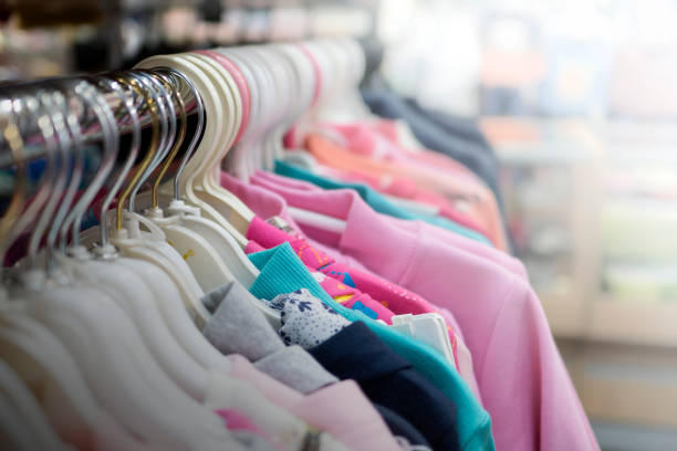 одежда висит на вешалке в магазине - child clothing arrangement hanger стоковые фото и изображения