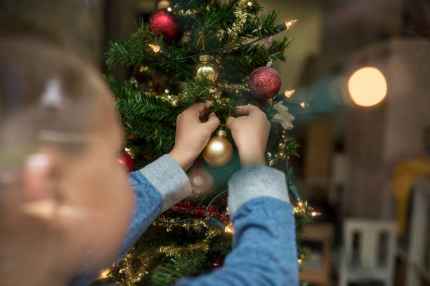 istock Rear view of a young boy decorating Christmas Tree 866375652
