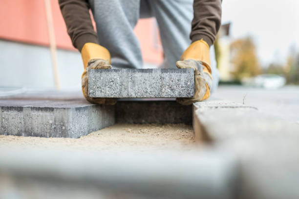 istock Man laying a paving brick placing it on the sand foundation 866376300