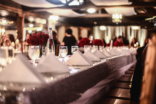 Looking down the table at placesetting with wine glasses, folded
