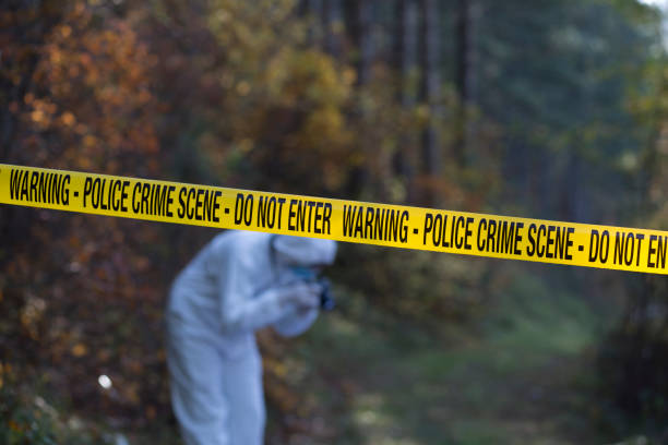 Crime scene investigation site Crime scene in the woods with the focus on the yellow cordon tape and forensic taking the picture bosnia and herzegovina photos stock pictures, royalty-free photos & images