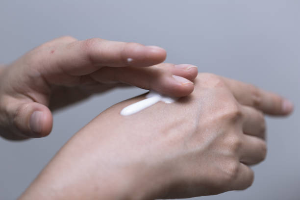istock Young woman is using white lotion on her hand, beauty concept 866388854