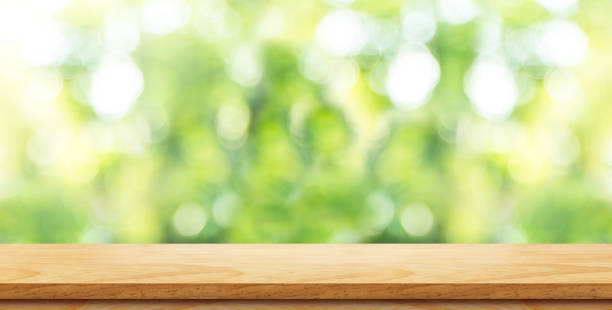 istock Empty brown wood table top with green blur nature background and sun light,Mock up for display or montage of product,panoramic view,banner size for advertise on online media 866389716
