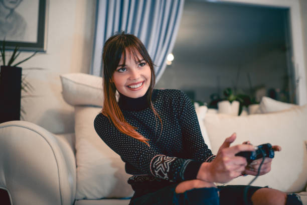istock Smiling Female Playing VIdeo Game at Home 866391868