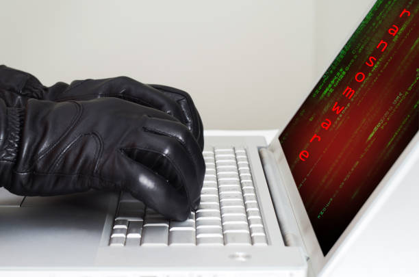 hacker avec des gants noirs à l’aide d’un ordinateur portable se préparent à attaquer à l’aide de ransomware - computer bug flash photos et images de collection