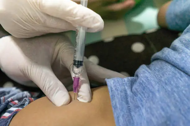 inject drug medicine syringe on hip by hand gloves doctor in action