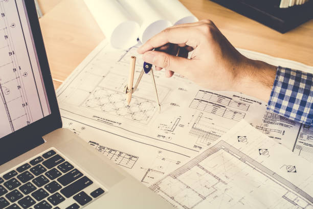 istock Concept architects,engineer holding pen pointing equipment architects On the desk with a blueprint in the office, Vintage, Sunset light.Selective Focus 866408432