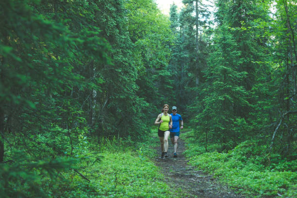 istock Older couple trail running in forest 866408582