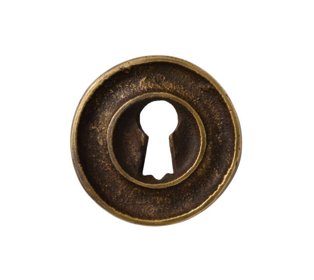 Brass keyhole against black background.