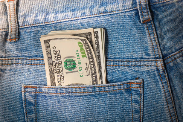 istock One hundred dollars pile sticking out of jeans pocket 866411280