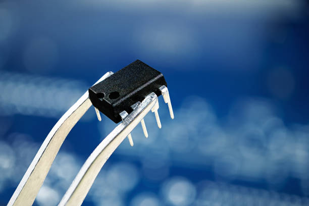 Microchip bios on tweezer,close up photo, blur bokeh blue background