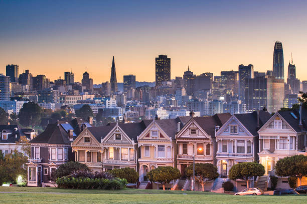 alamo square and painted ladies with san francisco skyline - san francisco bay area fotos imagens e fotografias de stock