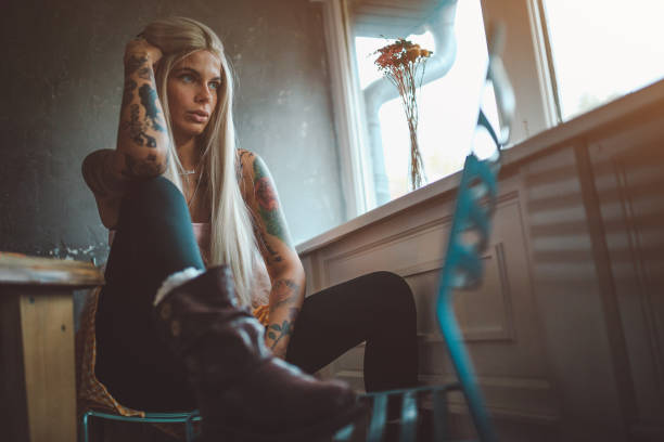 istock Beautiful tattooed woman looking through the window 866436856