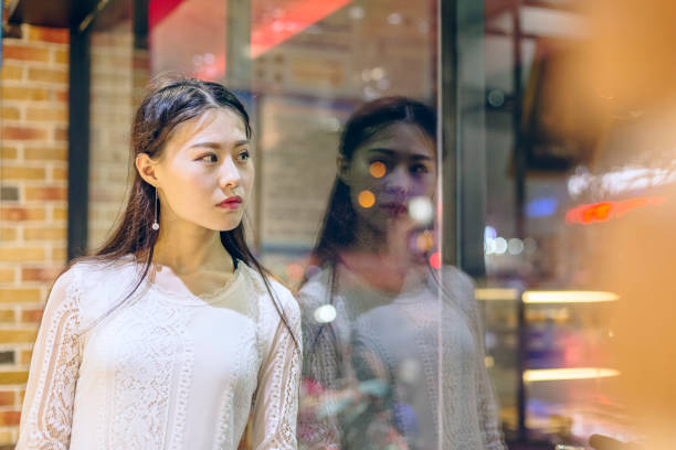 istock front view of woman looking out window 866437604