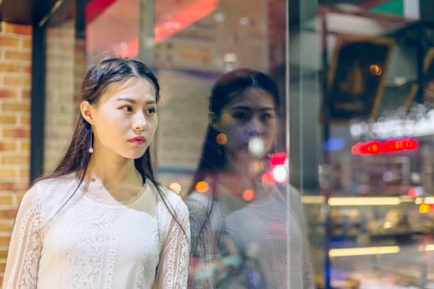 istock front view of woman looking out window 866437670