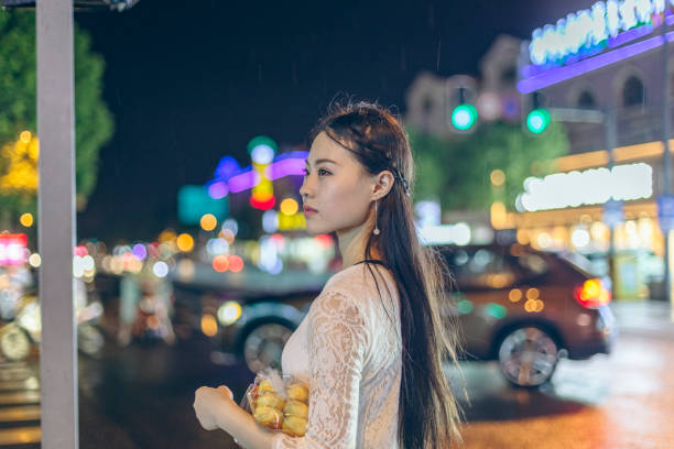 istock woman embracing bread standing at sidewalk at night 866438904