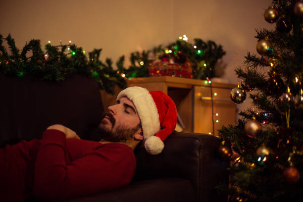 istock Young man wearing santa's hat sleeping during Christmas Eve 866440092