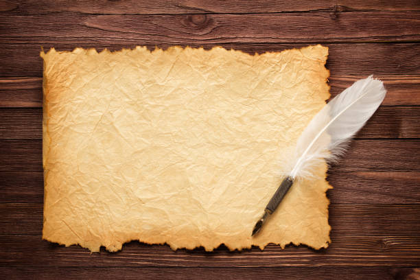istock White feather and old paper on wood surface 866440940