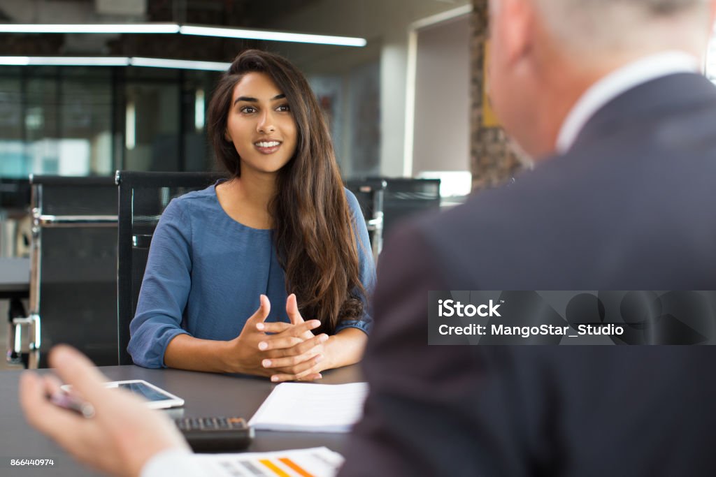 Cliente femminile sorridente che parla con il manager maschile - Foto stock royalty-free di Colloquio di lavoro