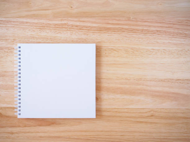 istock white cover notebook on brown wood desk background 866448318