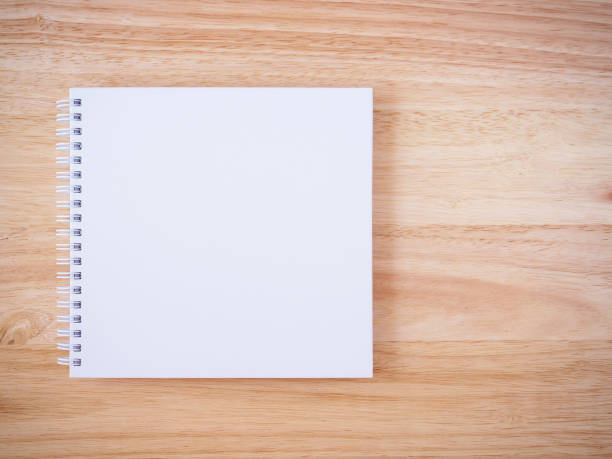 istock white cover notebook on brown wood desk background 866448322
