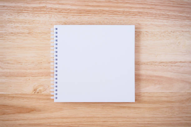 istock white cover notebook on brown wood desk background 866448328