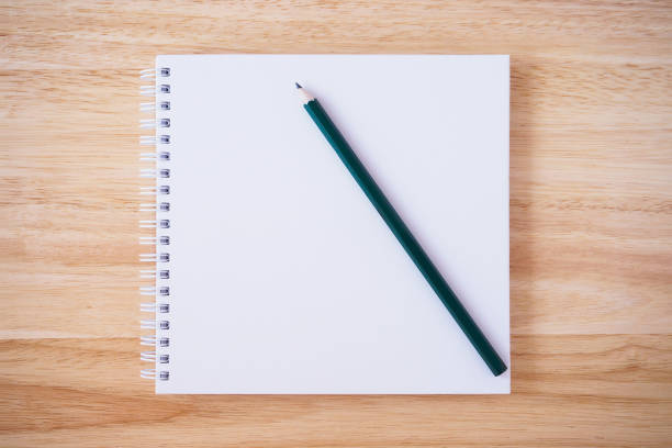 istock white cover notebook top view with pencil on brown wood desk 866448330