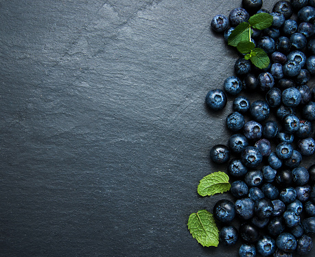 Fresh blueberries on a black  stone background