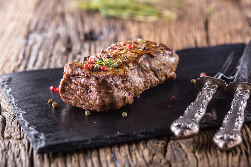 Beef Steak. Roasted Beef steak with salt pepper thyme on rustic wooden table.