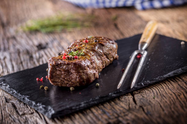 istock Beef Steak. Roasted Beef steak with salt pepper thyme on rustic wooden table 866464500