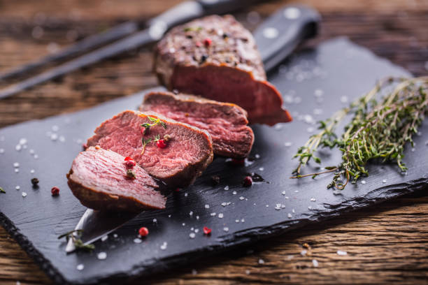istock Beef Steak. Roasted Beef steak with salt pepper thyme on rustic wooden table 866464520