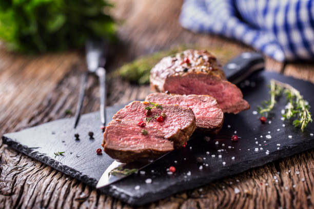 steak de bœuf. rôti de boeuf sauce thym sel poivre sur la table en bois rustique - eye fillet photos et images de collection