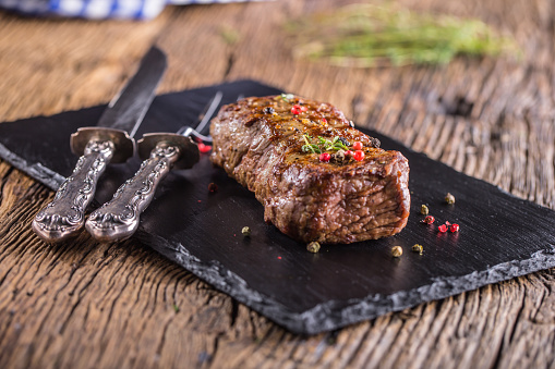 Beef Steak. Roasted Beef steak with salt pepper thyme on rustic wooden table.