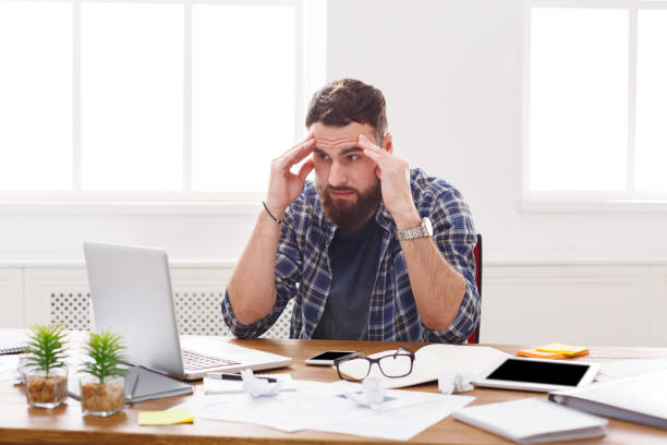 istock Young stressed businessman with laptop in modern white office 866467682