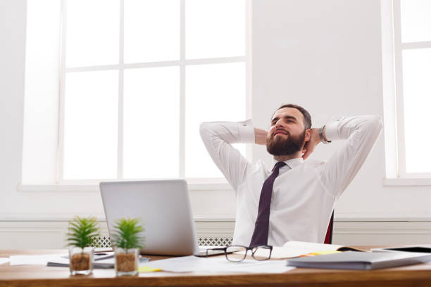 istock Happy and relaxed businessman with laptop in modern white office 866467814