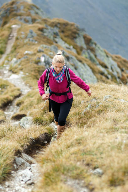 istock Woman backpacker hiking on a trail 866468542