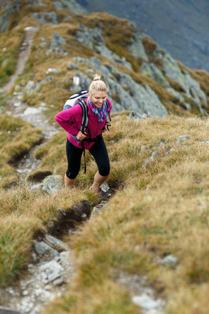 istock Woman backpacker hiking on a trail 866468558