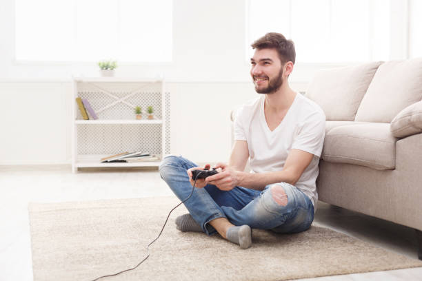 istock Happy young man at home playing video games 866468634