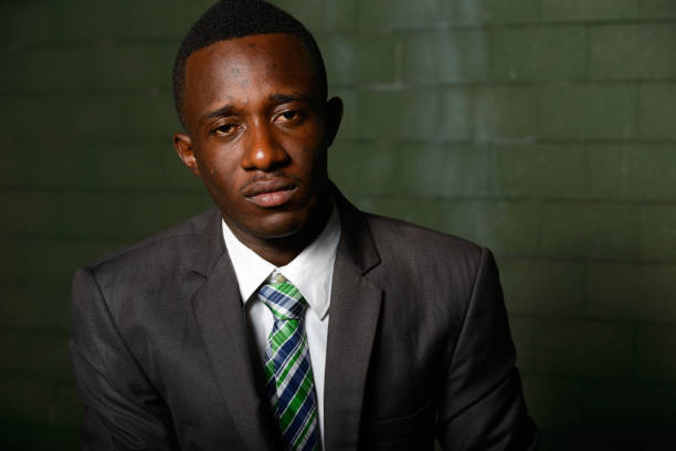 istock Young African businessman against brick wall outdoors at night 866474844