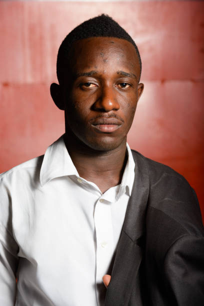 istock Young African businessman against red iron wall outdoors at night 866475200