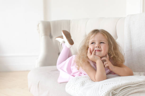 istock Charming little girl posing on sofa 866483952
