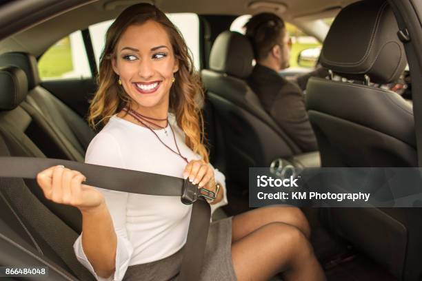 Beautiful Businesswoman Putting On Seatbelt In Car Stock Photo - Download Image Now - Chauffeur, Passenger, Car