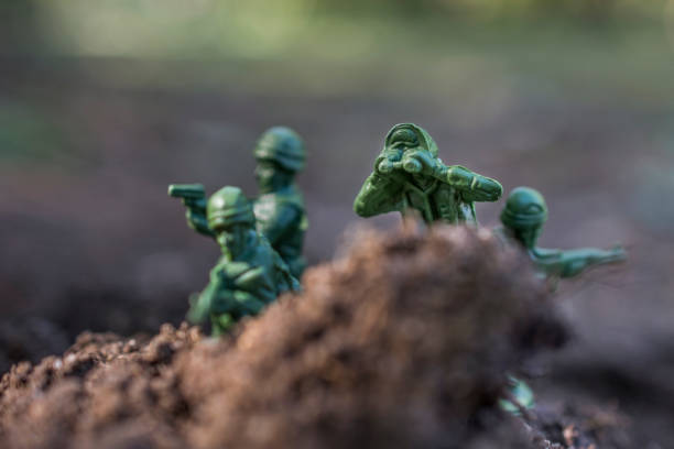 Toy soldiers watching from the mud stock photo