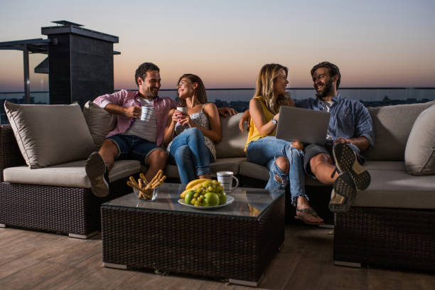 istock Young couples relaxing on the sofa at penthouse terrace. 866491474