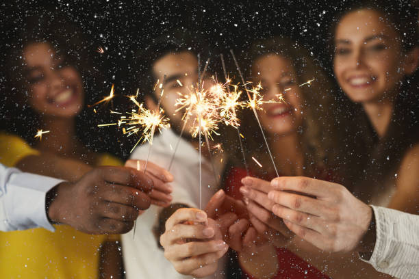 Sparklers background. Young people at celebration party Holiday background with sparklers. Young friends holding bengal lights, closeup, selective focus. Birthday or winter holidays celebration, greeting card mockup new year photos stock pictures, royalty-free photos & images