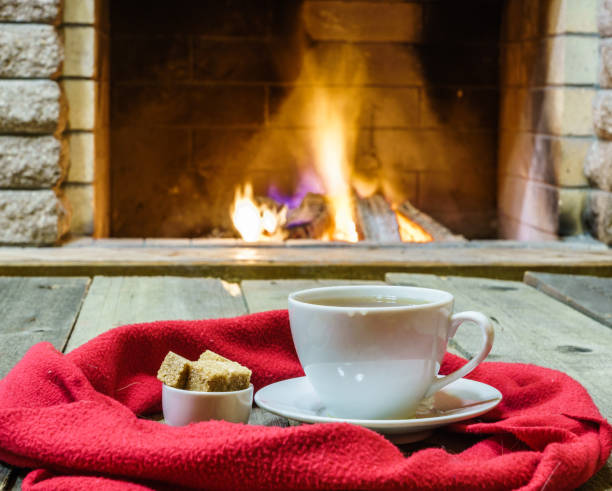 istock Cup of tea and sugar,  wool  things near  cozy fireplace. 866497454