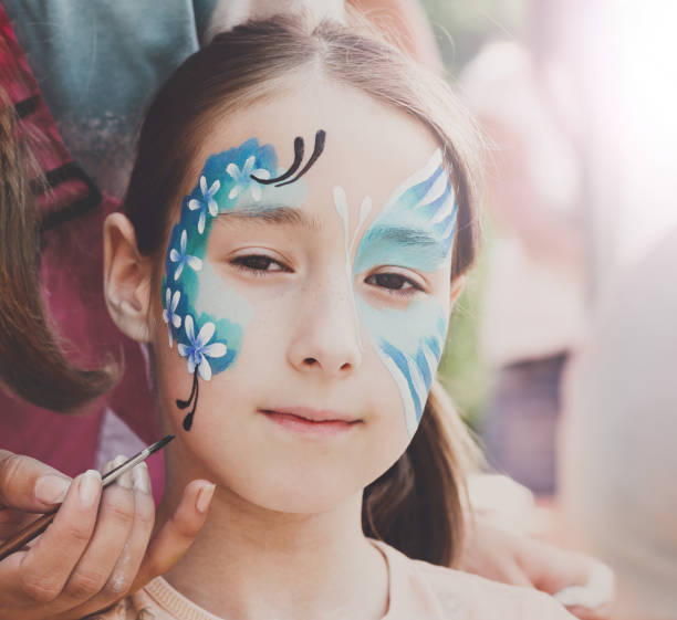 istock Female child face painting, making butterfly process 866498486