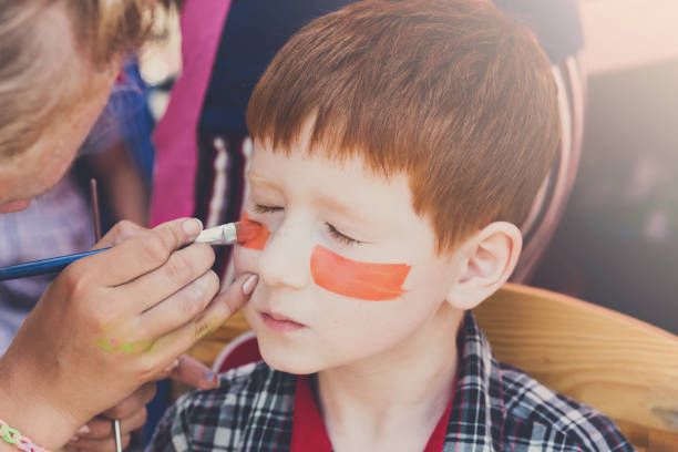 istock Child boy face painting, making tiger eyes process 866498654
